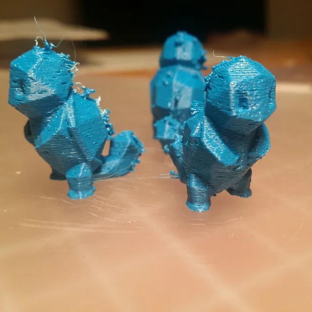 3D printed figures with fine plastic wisps and stringing between surfaces